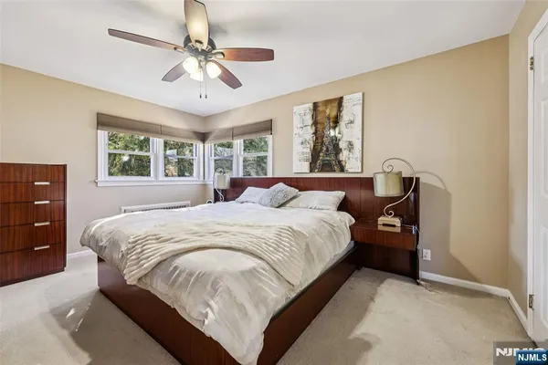 a spacious bedroom with a large bed and a chandelier
