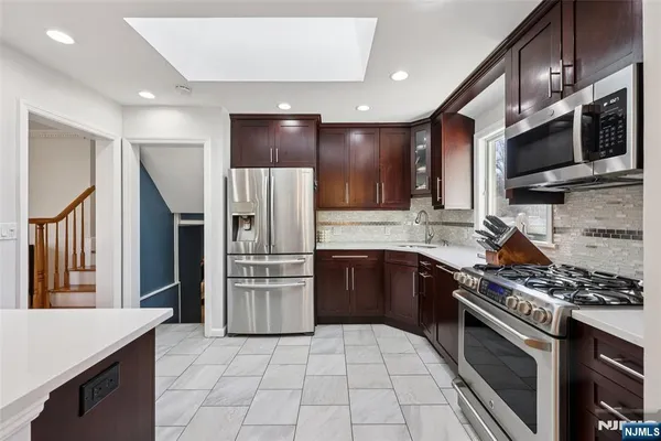 a kitchen with stainless steel appliances granite countertop a refrigerator stove and microwave