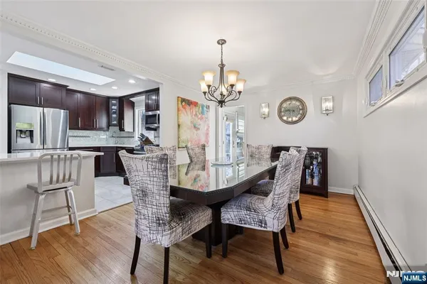 a view of a dining room with furniture a chandelier and wooden floor