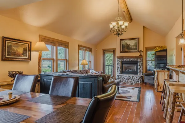 a view of a dining room with furniture a chandelier and wooden floor