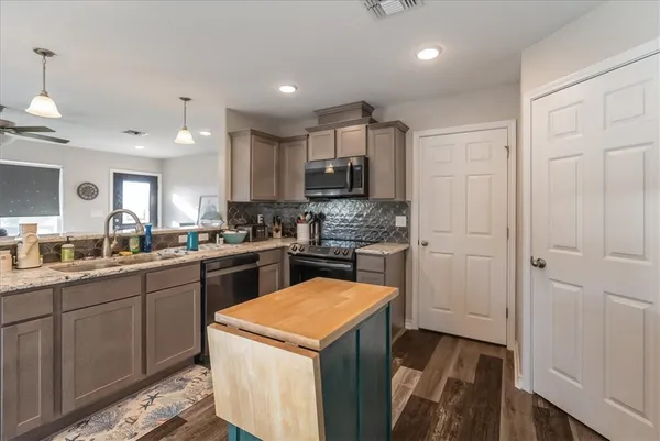 a kitchen with a sink a stove and cabinets