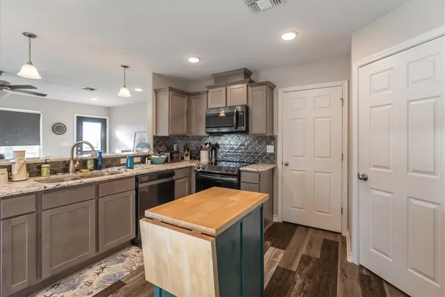 a kitchen with a sink a stove and cabinets