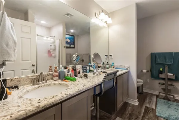 a bathroom with a granite countertop sink double vanity and a mirror