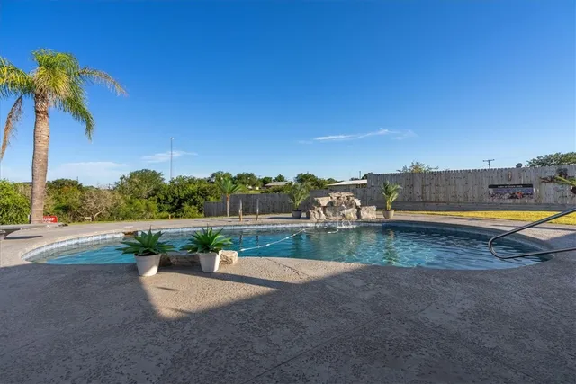 a view of swimming pool with seating area and lake view