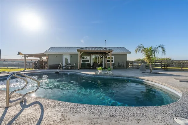 a view of a house with backyard patio and swimming pool