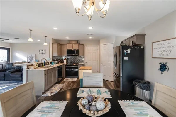 a kitchen with stainless steel appliances kitchen island granite countertop a refrigerator a sink and a stove