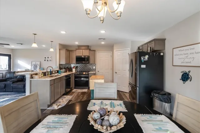 a kitchen with stainless steel appliances kitchen island granite countertop a refrigerator a sink and a stove