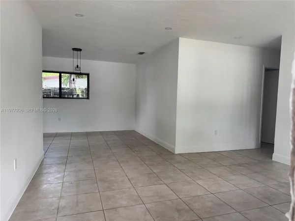 an empty room with windows and cabinet