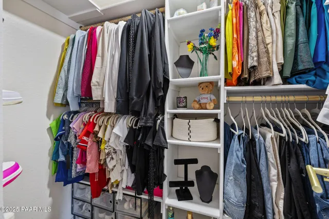 a view of walk in closet with clothes and shoes