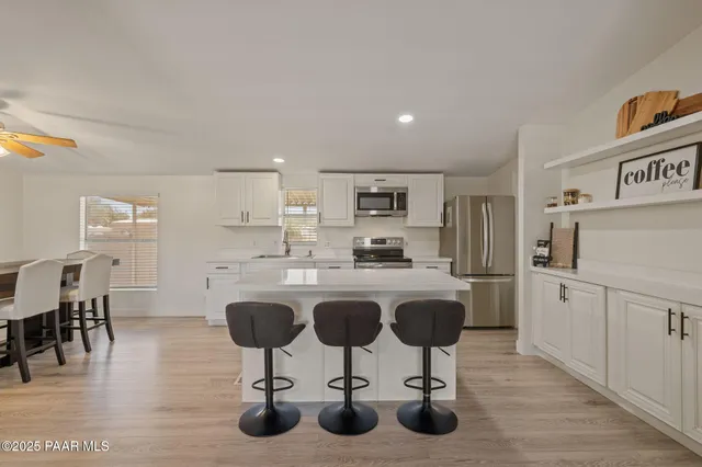 a kitchen with stainless steel appliances kitchen island granite countertop a table chair and granite counter tops