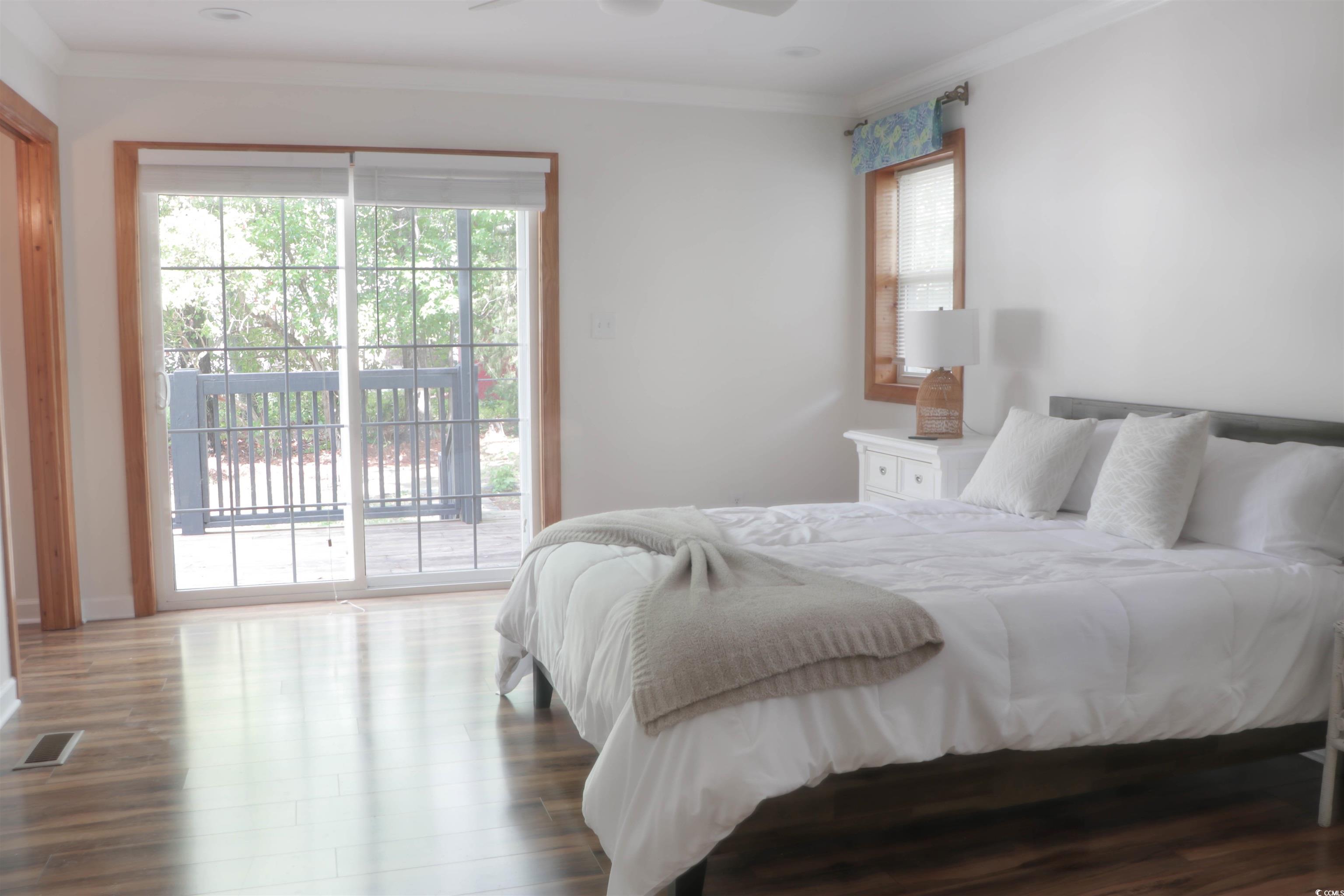 1014 Bay Drive Surfside Beach, SC 29575 - Photo 18 of 27 Bedroom featuring access to outside, crown molding, wood finished floors, and baseboards