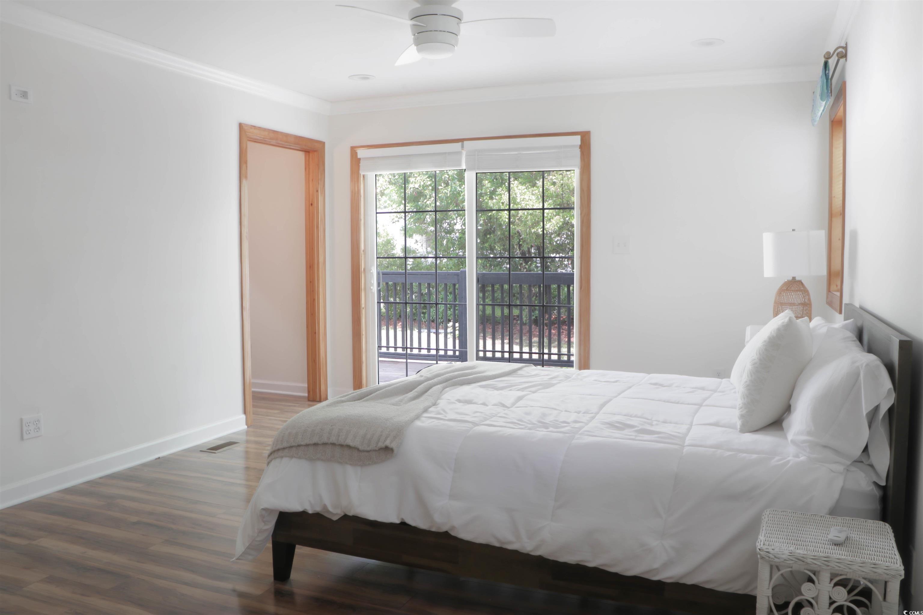 1014 Bay Drive Surfside Beach, SC 29575 - Photo 19 of 27 Bedroom with access to outside, wood finished floors, crown molding, baseboards, and ceiling fan