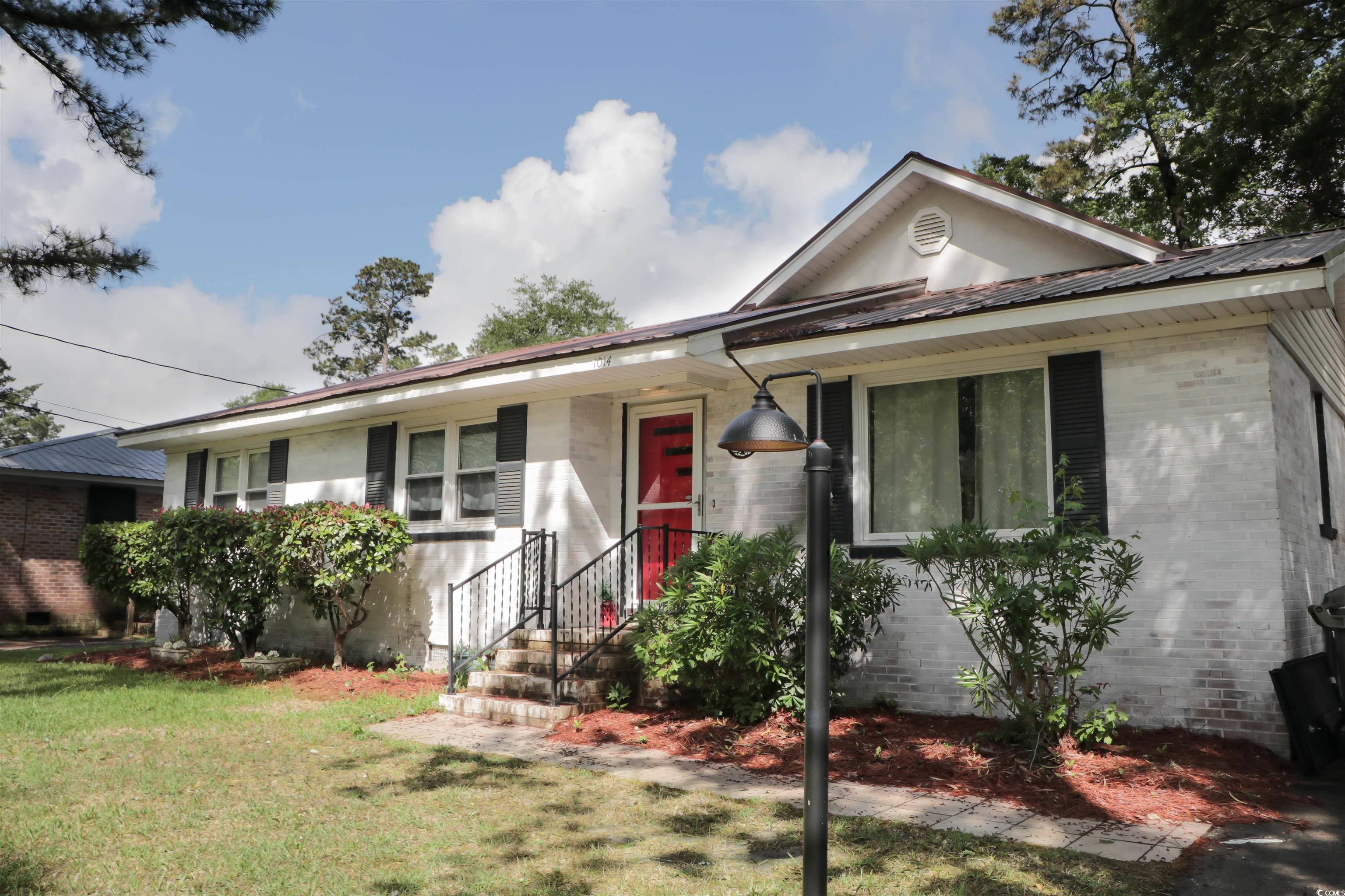1014 Bay Drive Surfside Beach, SC 29575 - Photo 2 of 27 Ranch-style house with brick siding, a front yard, and metal roof