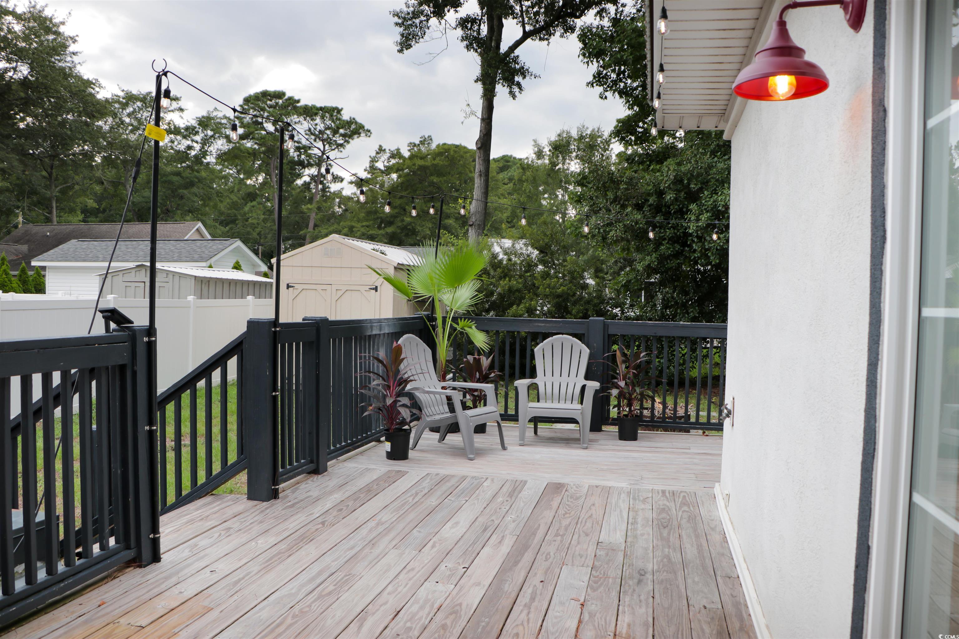 1014 Bay Drive Surfside Beach, SC 29575 - Photo 23 of 27 Wooden terrace featuring a storage unit and view of wooded area