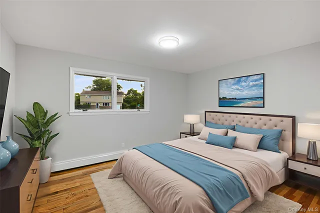 a bedroom with a large bed and a potted plant