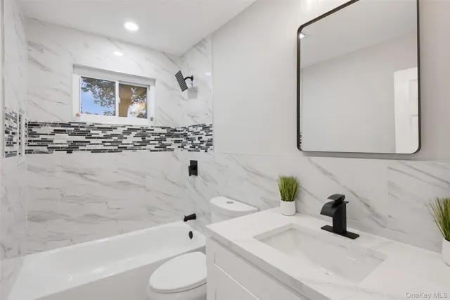 a bathroom with a tub sink and mirror