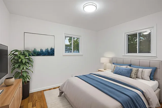 a bedroom with a bed table and a potted plant