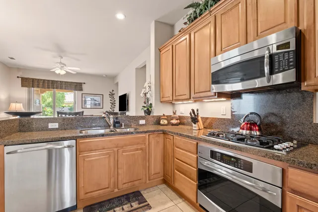 a kitchen with stainless steel appliances a sink a stove and cabinets
