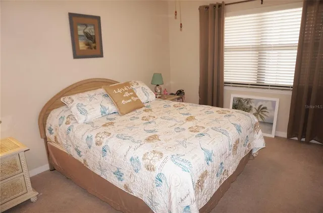 a large bed sitting in a bedroom next to a window