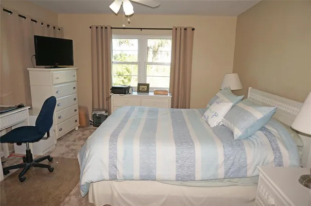 a spacious bedroom with a bed and a flat screen tv