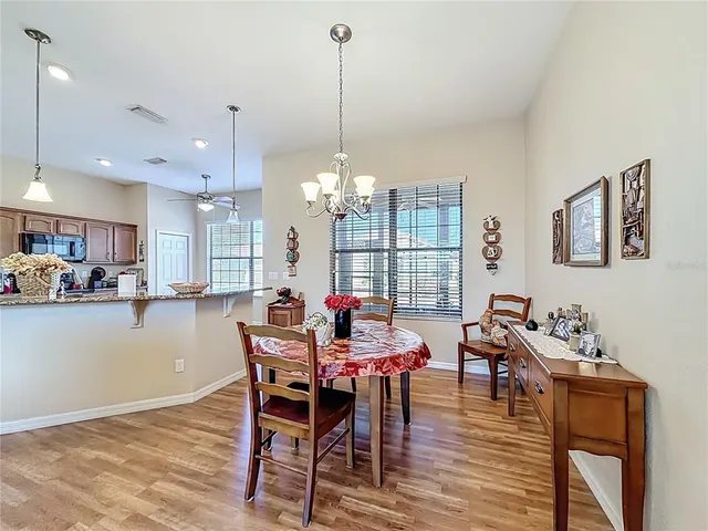a view of a dining room and livingroom with furniture wooden floor a rug a chandelier
