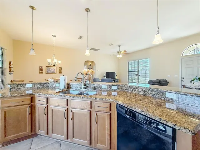 a kitchen with kitchen island granite countertop a sink a stove and cabinets