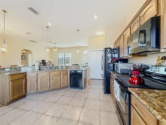 a kitchen with stainless steel appliances granite countertop a stove a sink and a refrigerator