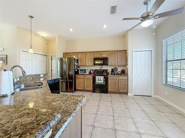 a kitchen with stainless steel appliances granite countertop a stove top oven a sink a counter space and cabinets