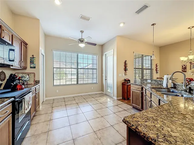 a kitchen with stainless steel appliances granite countertop a stove top oven a sink a counter space and cabinets