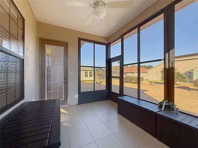 a spacious bedroom with a large window and a chandelier