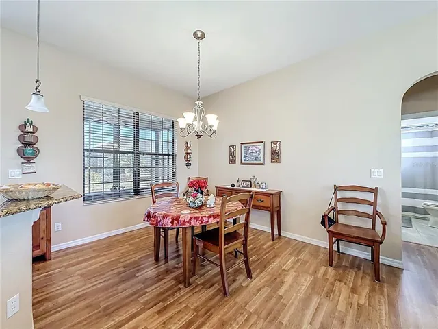 a dining room with furniture a chandelier and wooden floor