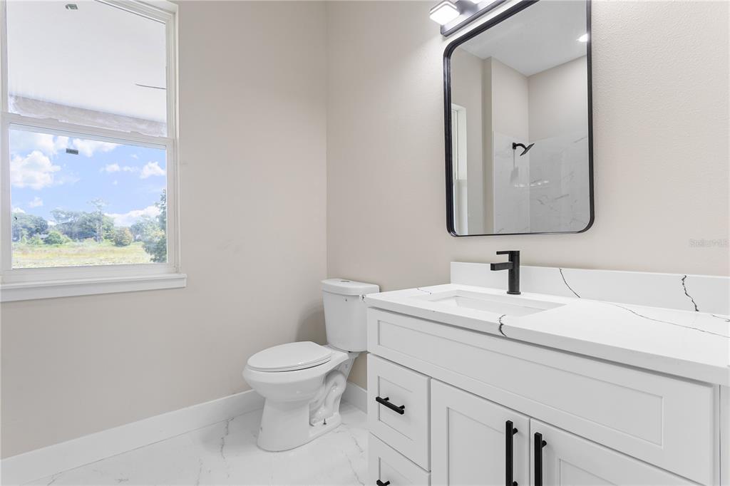 33328 County Road 473 Leesburg, FL 34788 - Photo 15 of 28 a bathroom with a toilet sink and mirror
