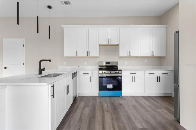a kitchen with stainless steel appliances a sink stove and cabinets