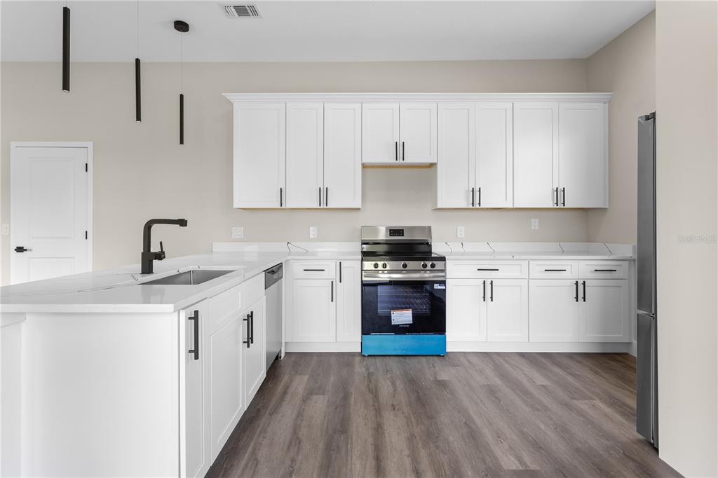 33328 County Road 473 Leesburg, FL 34788 - Photo 18 of 28 a kitchen with stainless steel appliances a sink stove and cabinets