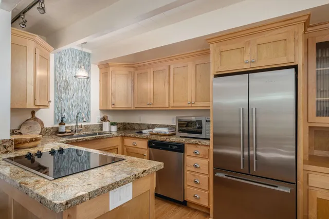 a kitchen with a refrigerator sink and cabinets
