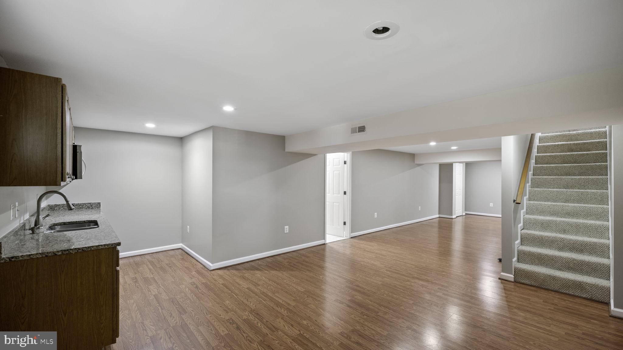 9705 Eclipse Place Montgomery Village, MD 20886 - Photo 40 of 54 a view of an empty room with wooden floor and a cabinet