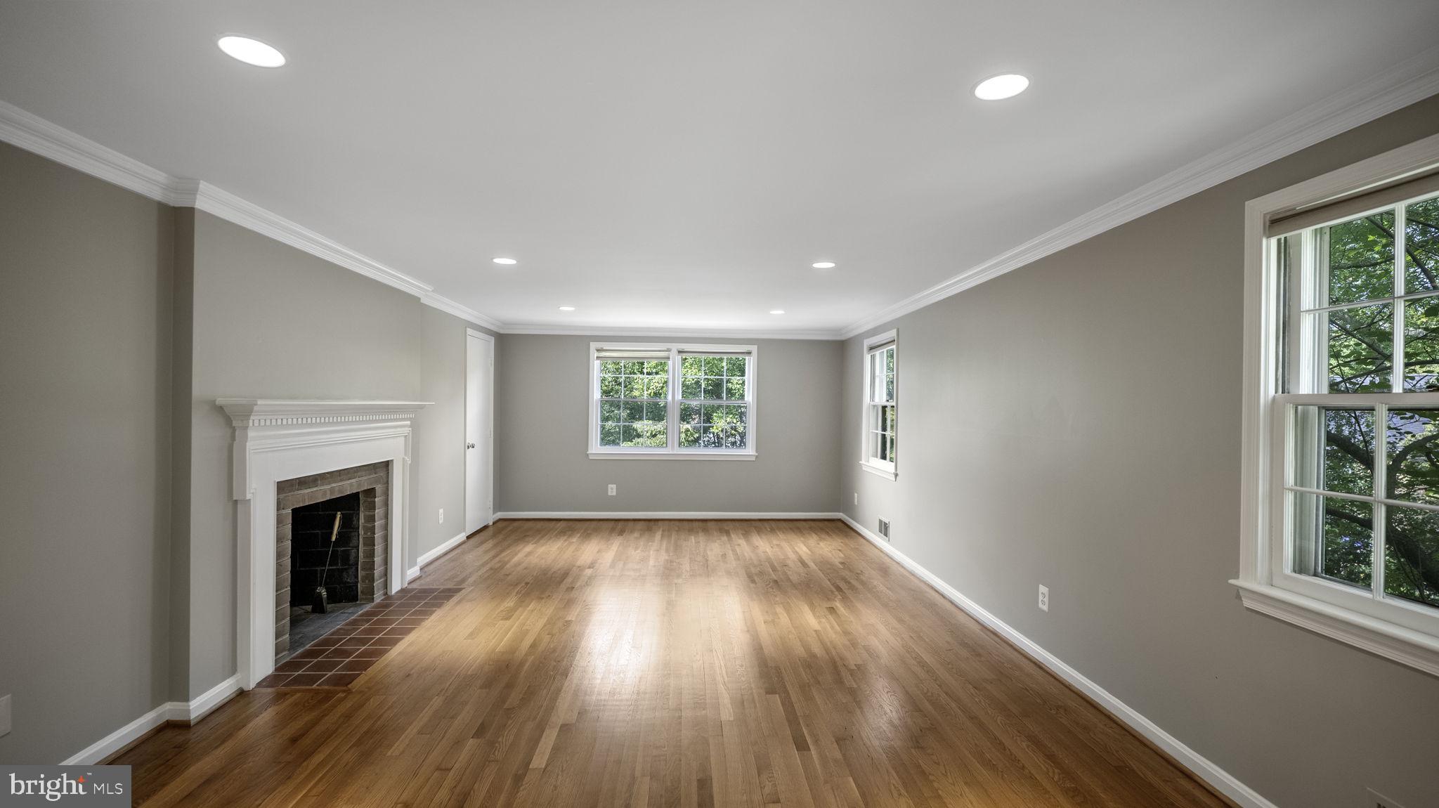 9705 Eclipse Place Montgomery Village, MD 20886 - Photo 9 of 54 an empty room with wooden floor fireplace and windows
