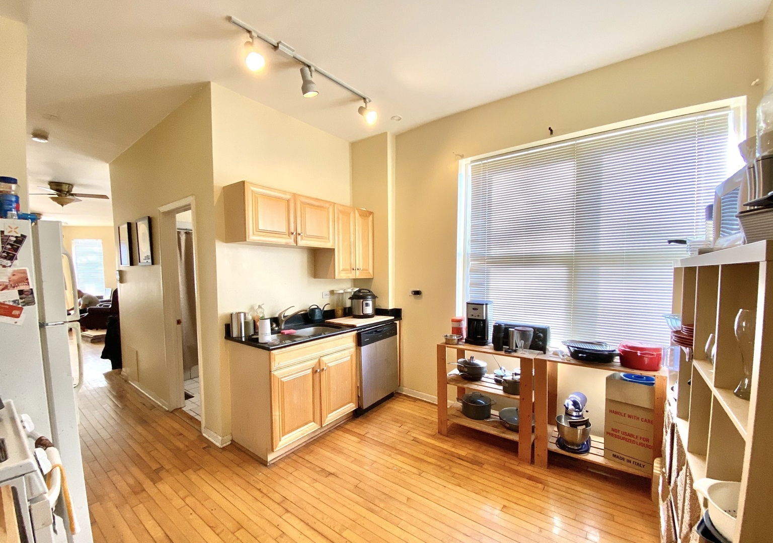2610 West Thomas Street, Unit 1F Chicago, IL 60622 - Photo 2 of 13 a kitchen with stainless steel appliances granite countertop a stove top oven a refrigerator a dining table and chairs with wooden floor