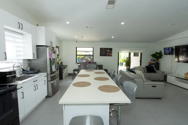 a large kitchen with cabinets a sink a counter space and stainless steel appliances