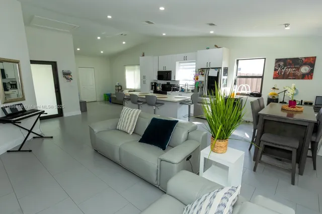 a living room with furniture and a dining table with kitchen view