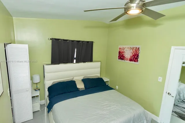 a bedroom with a bed and a mirror on the wall