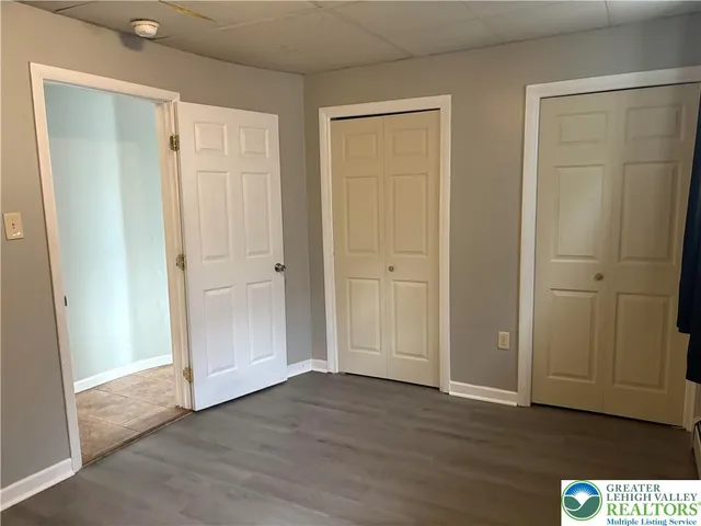 an empty room with wooden floor and closet area