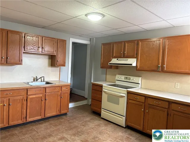 a kitchen with sink a microwave and cabinets