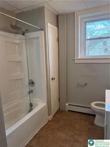a bathroom with a shower a bathtub and a toilet