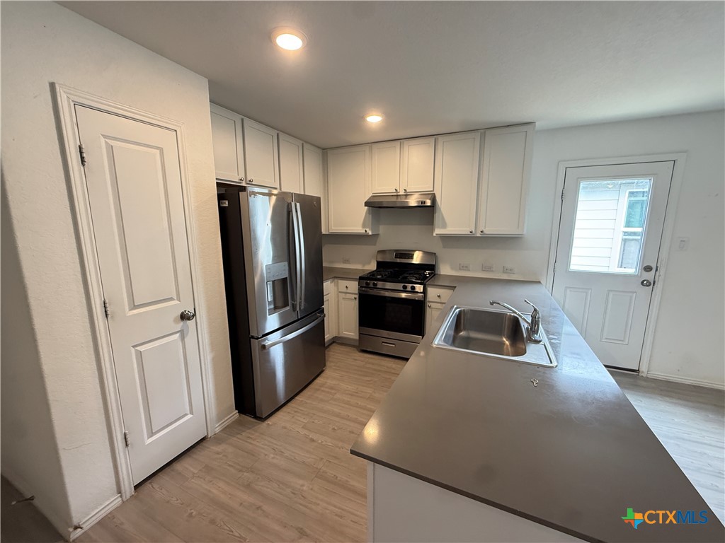 5863 Coahulia Ridge Seguin, TX 78155 - Photo 5 of 15 a kitchen with stainless steel appliances granite countertop a refrigerator sink and stove