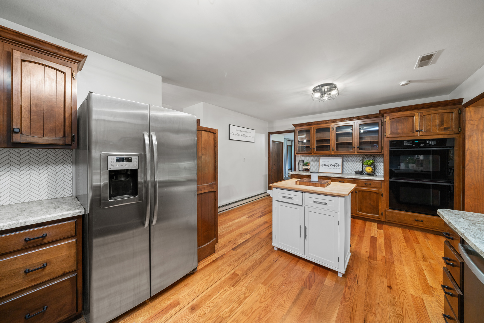 1102 Vale Street Sandwich, IL 60548 - Photo 12 of 44 a kitchen with stainless steel appliances wooden floor a refrigerator and wooden cabinets