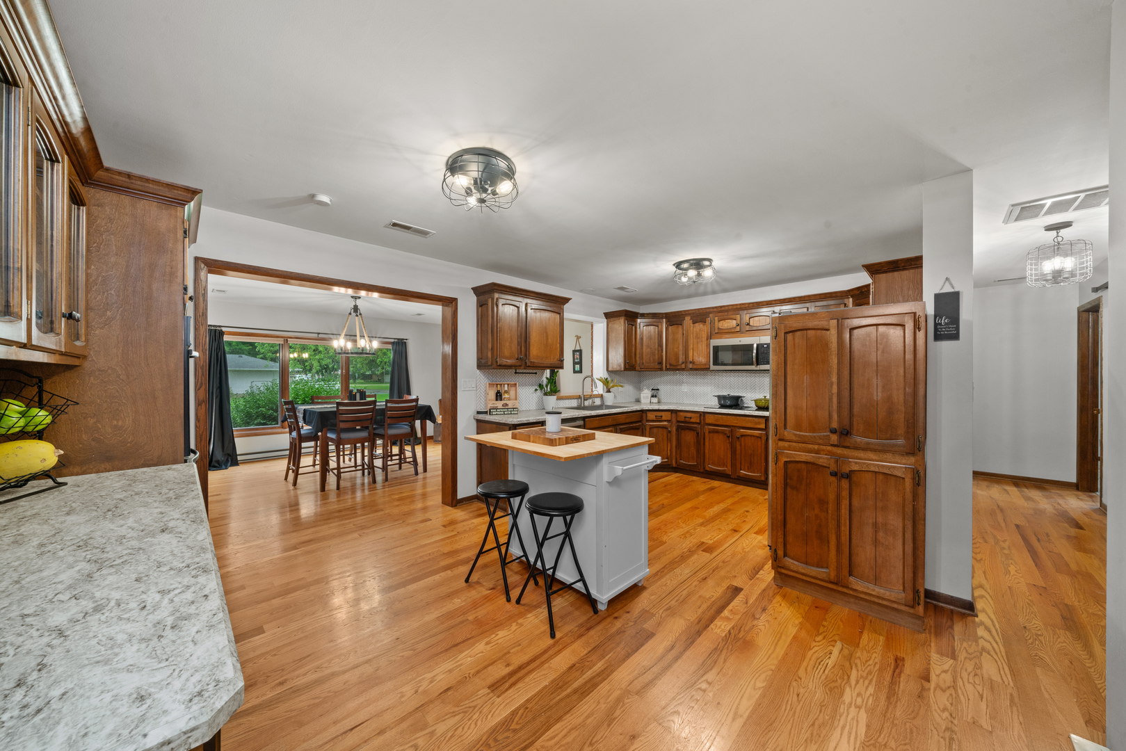 1102 Vale Street Sandwich, IL 60548 - Photo 9 of 44 a kitchen with stainless steel appliances granite countertop a refrigerator a stove top oven and a dining table with wooden floor