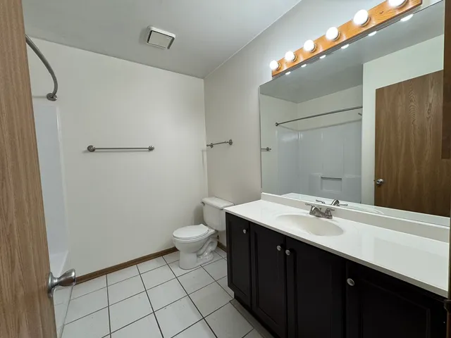 a bathroom with a sink a toilet and a mirror