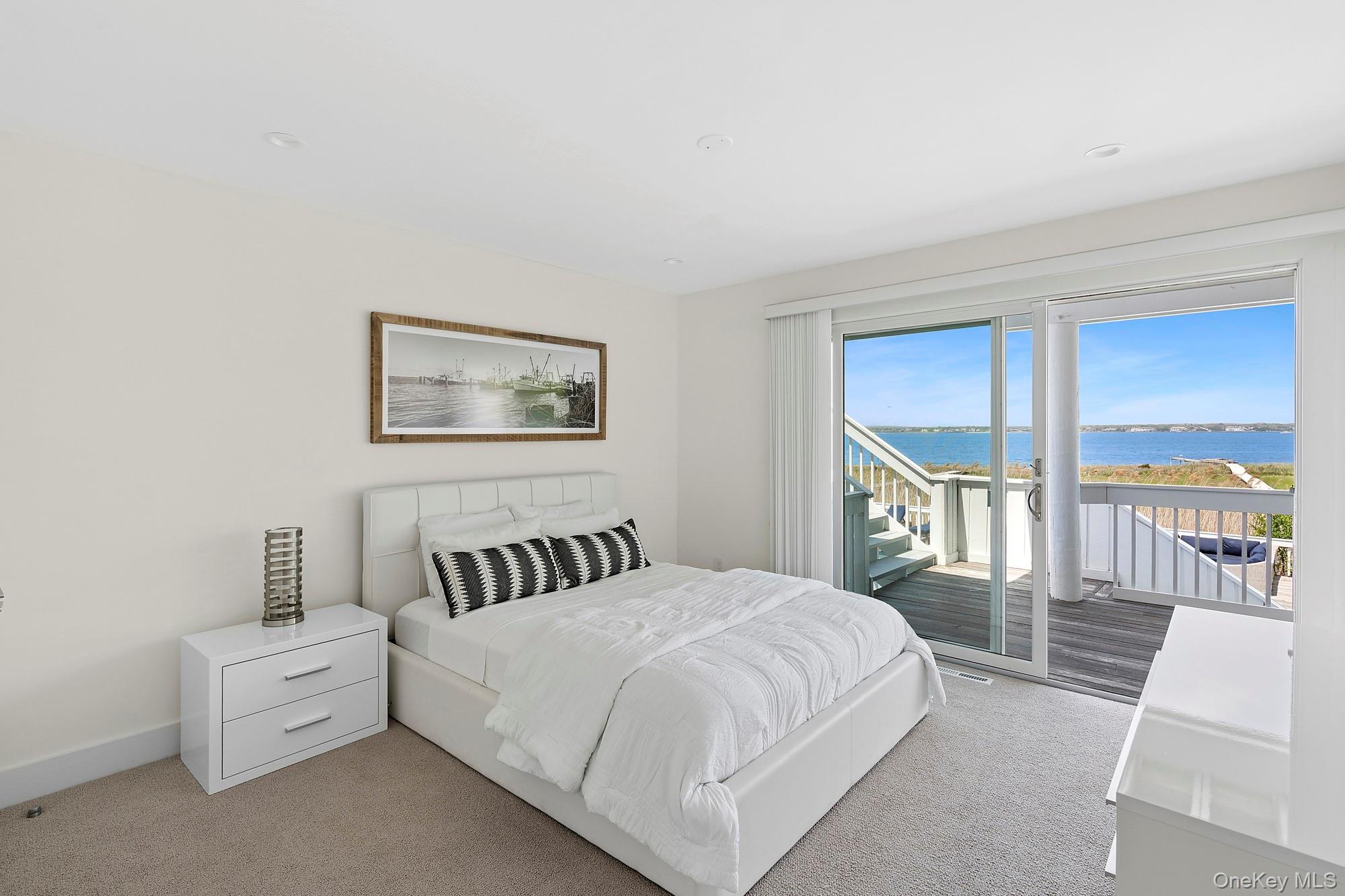 588 Dune Road Westhampton, NY 11978 - Photo 14 of 23 a bedroom with a large bed and a night stand