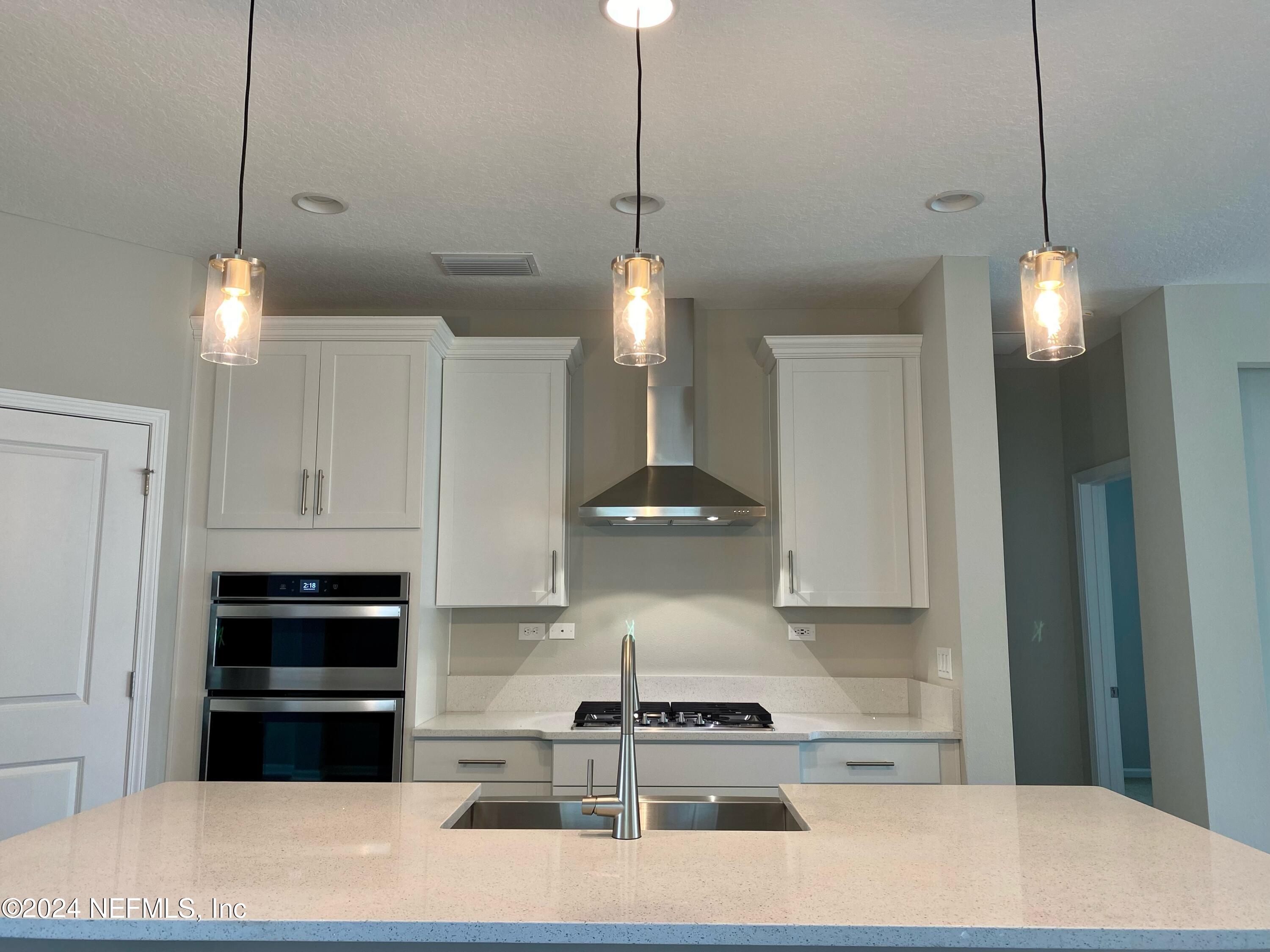182 Holly Forest Drive St. Augustine, FL 32092 - Photo 12 of 29 a kitchen with stainless steel appliances granite countertop a stove a refrigerator and a white cabinets